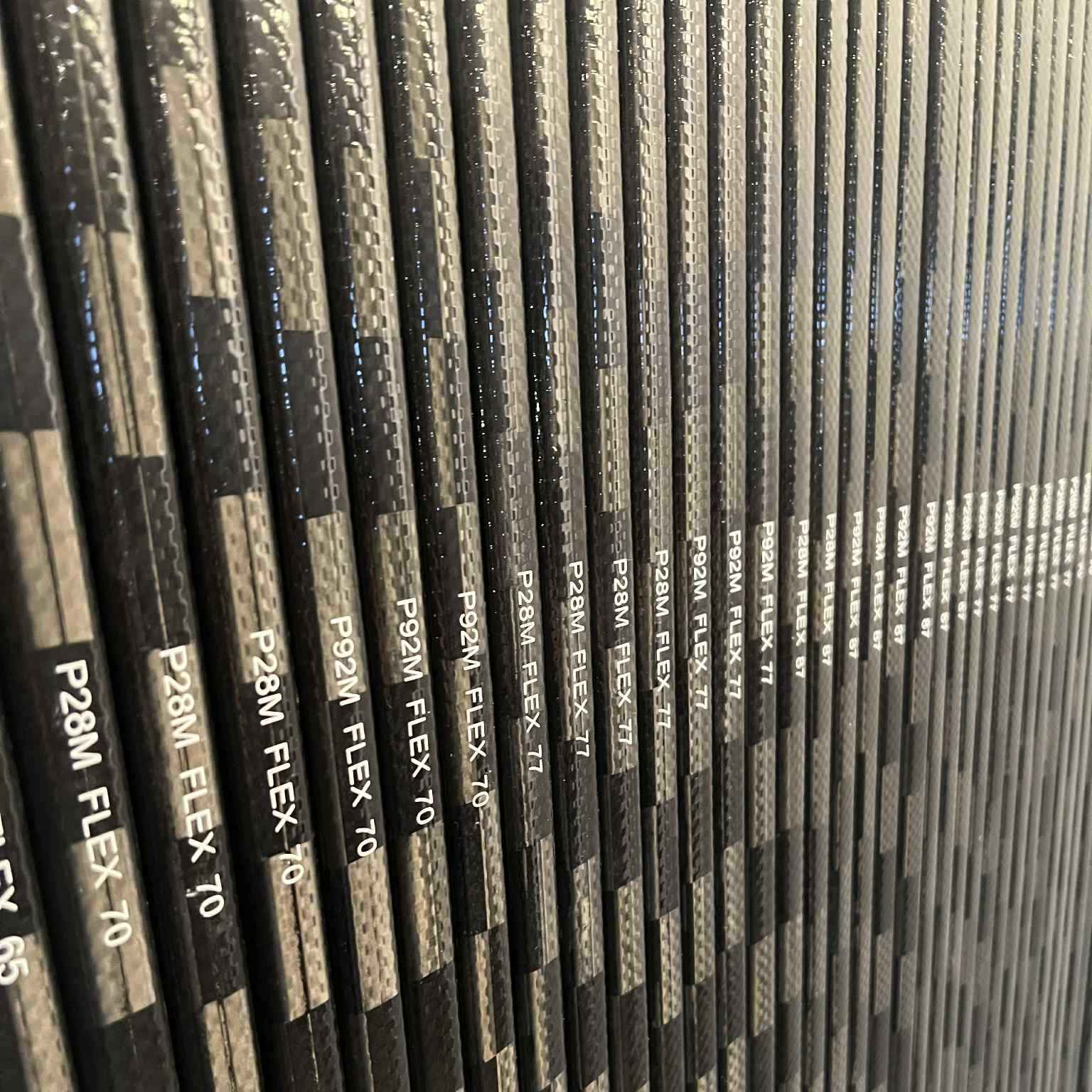 Alignement de bâtons de hockey en carbone LabSports Pro All Black avec différentes courbes et flex, collection 2026 conçue pour la performance et la durabilité